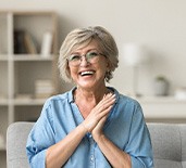 Older woman smiling after receiving dentures