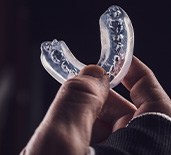 Closeup of person holding clear mouthguard