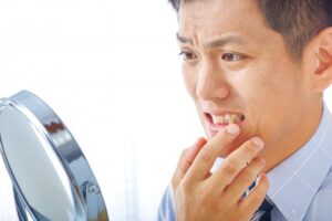 Man examining his stained teeth and frowning