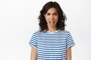 Woman sticking her tongue out on white background